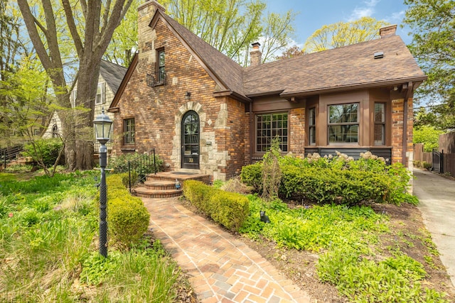 33 Sylvan Ave, Pleasant Ridge, MI 48069 - tudor-style house with a chimney, brick siding, a shingled roof, and fence