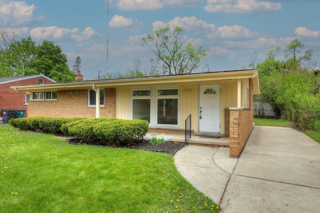 single story home with brick siding, a front lawn, and a chimney
