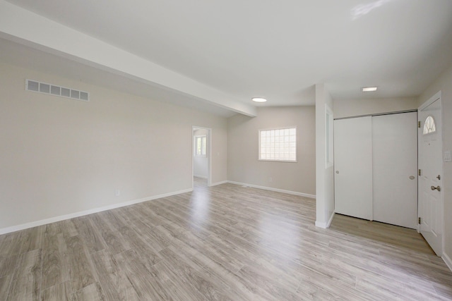 unfurnished room with light wood-type flooring and baseboards