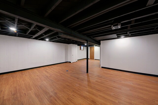 finished basement featuring wood finished floors and baseboards