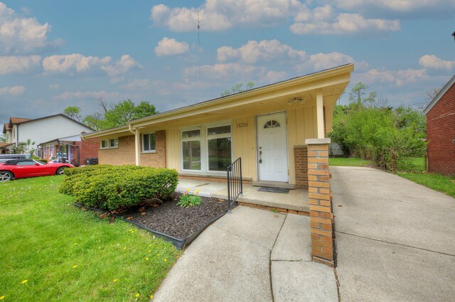 ranch-style house with a front yard and brick siding