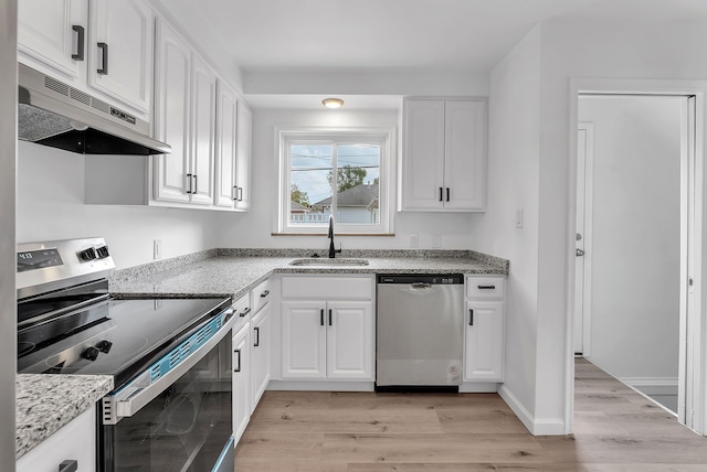 kitchen featuring light wood-style flooring, a sink, under cabinet range hood, appliances with stainless steel finishes, and light stone counters