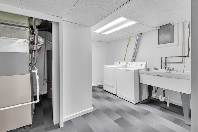 clothes washing area featuring washing machine and dryer, laundry area, electric panel, and baseboards