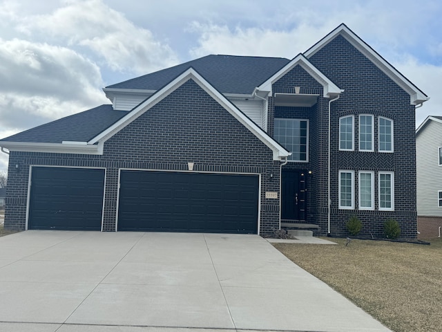 traditional-style home with concrete driveway, a front yard, brick siding, and a garage