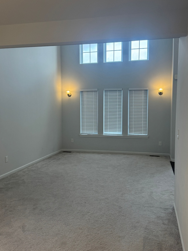 unfurnished room featuring carpet floors and baseboards