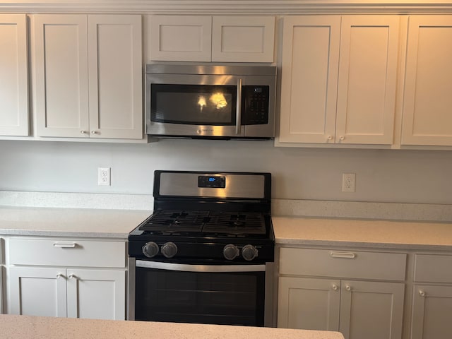 kitchen with white cabinets and appliances with stainless steel finishes