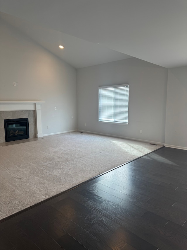 unfurnished living room with wood finished floors, a fireplace, baseboards, and recessed lighting