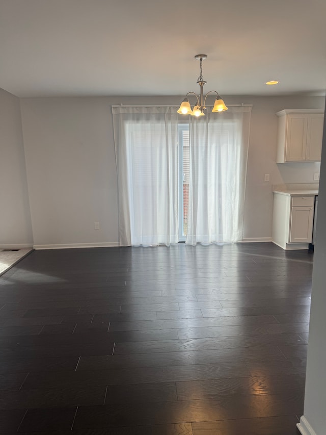interior space with recessed lighting, dark wood finished floors, baseboards, and a notable chandelier