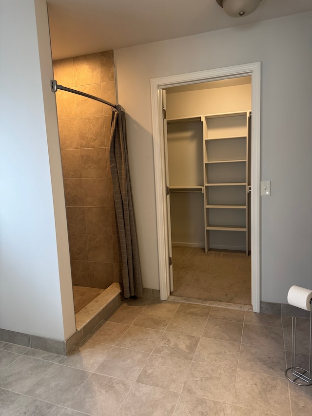 bathroom with a stall shower and a walk in closet