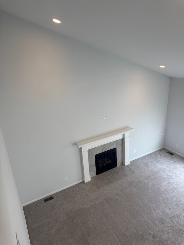 unfurnished living room featuring visible vents, recessed lighting, carpet floors, baseboards, and a tile fireplace