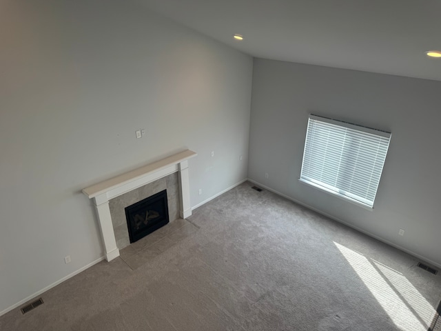 unfurnished living room with recessed lighting, a tile fireplace, visible vents, and carpet floors