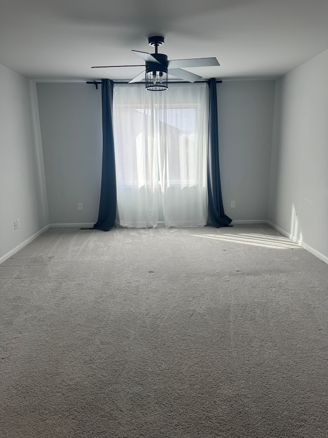 carpeted spare room with baseboards and ceiling fan