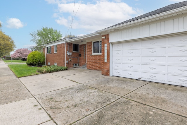 view of front of house featuring brick siding, driveway, and a garage