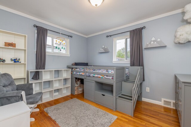 bedroom featuring wood finished floors, baseboards, and ornamental molding