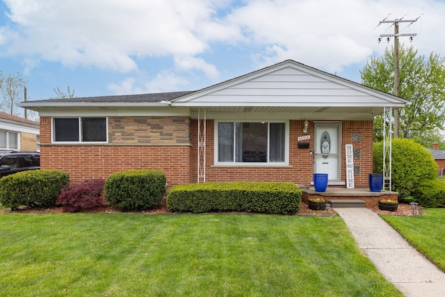 bungalow-style home featuring a front lawn and brick siding