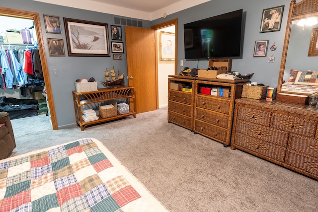 bedroom featuring carpet flooring, a closet, visible vents, and a walk in closet