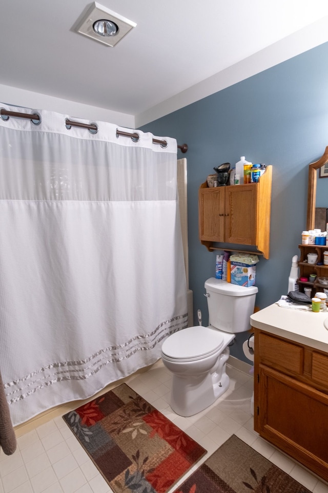 bathroom with toilet, a shower with curtain, vanity, and tile patterned flooring