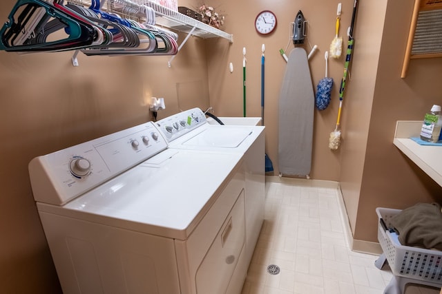 clothes washing area featuring washing machine and dryer, laundry area, and baseboards