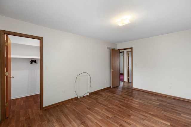 empty room with visible vents, wood finished floors, and baseboards