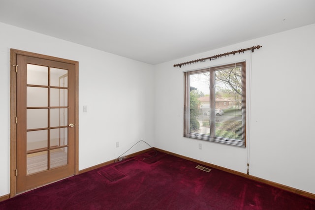 carpeted empty room featuring visible vents and baseboards