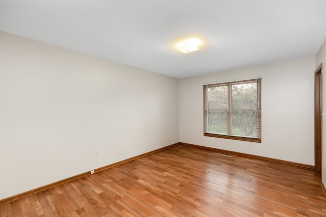 unfurnished room with baseboards and light wood finished floors