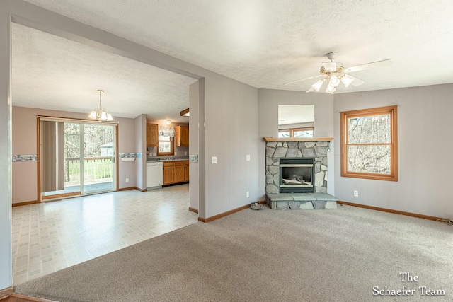 unfurnished living room featuring a textured ceiling, baseboards, ceiling fan, light carpet, and a fireplace
