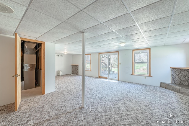 basement with a paneled ceiling, visible vents, and carpet floors