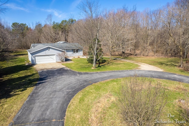 view of front of property with aphalt driveway, a front lawn, and an attached garage