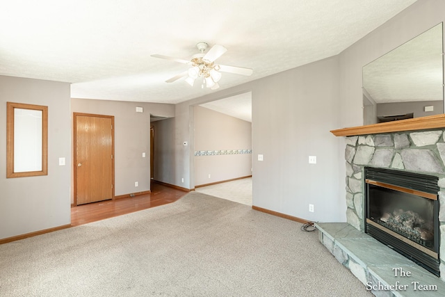 unfurnished living room featuring a fireplace, ceiling fan, carpet, and baseboards