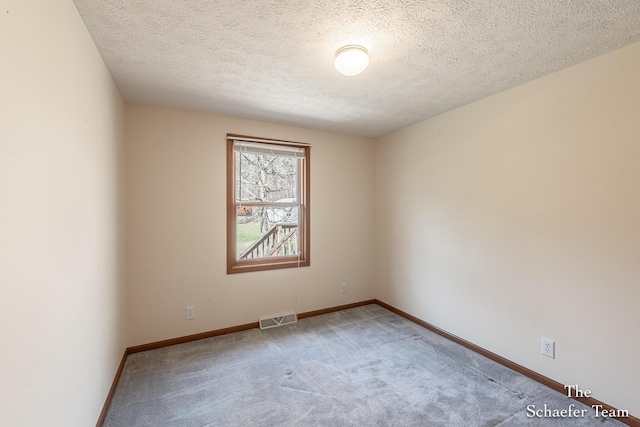 carpeted empty room featuring a textured ceiling, visible vents, and baseboards