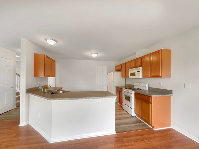 1555 S Harris Rd, Ypsilanti, MI 48198 - kitchen featuring a sink, a peninsula, white appliances, and light wood-type flooring