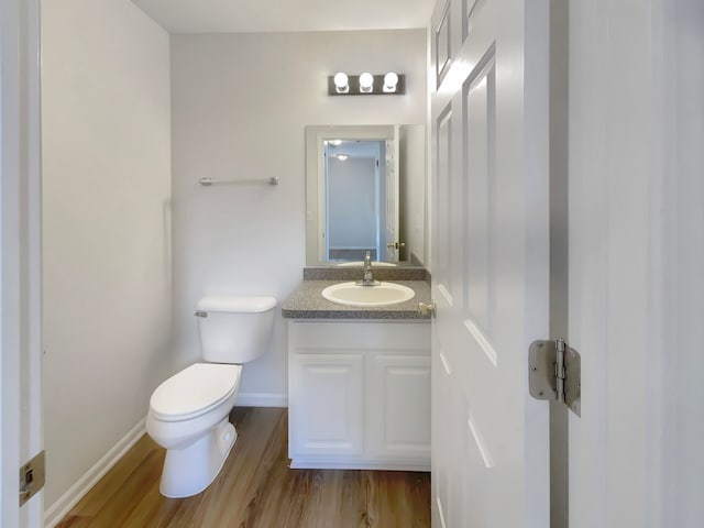 1555 S Harris Rd, Ypsilanti, MI 48198 - bathroom featuring toilet, baseboards, wood finished floors, and vanity