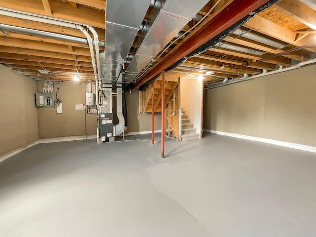 1555 S Harris Rd, Ypsilanti, MI 48198 - unfinished below grade area with electric panel, stairway, baseboards, and heating unit