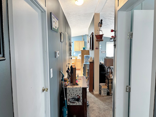 corridor featuring a textured ceiling and carpet floors