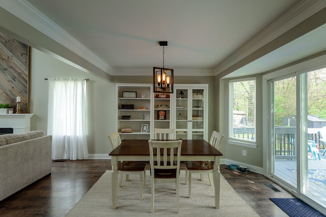 dining area with a chandelier, healthy amount of natural light, dark wood-type flooring, and ornamental molding