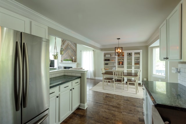 kitchen with freestanding refrigerator, a chandelier, ornamental molding, white cabinetry, and dark wood-type flooring