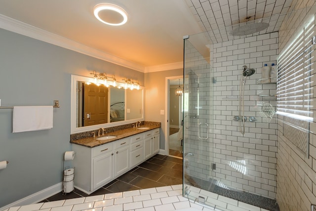 full bath featuring a shower stall, crown molding, tile patterned floors, double vanity, and baseboards