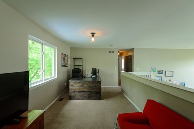 living area with carpet flooring, baseboards, and a desk
