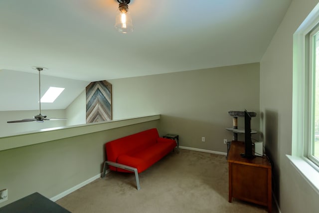 living area with a skylight, carpet, healthy amount of natural light, baseboards, and vaulted ceiling