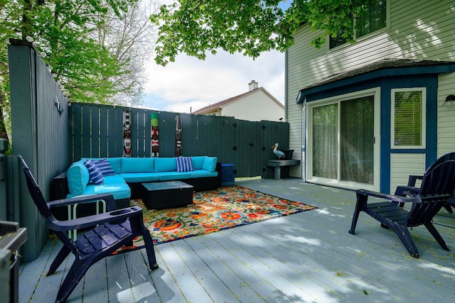 wooden deck featuring outdoor lounge area and a fenced backyard