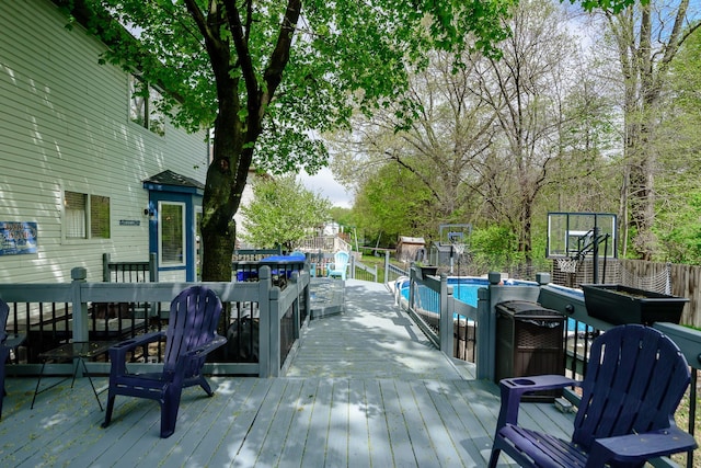 wooden terrace featuring a fire pit and an outdoor pool