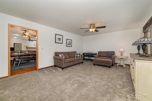 living room featuring light colored carpet, baseboards, and ceiling fan