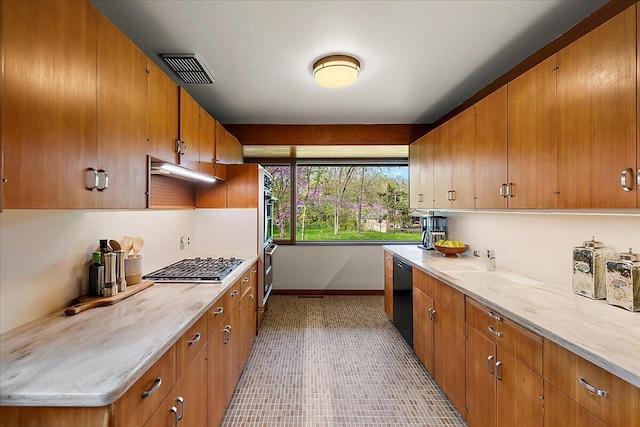 kitchen featuring brown cabinets, light countertops, and stainless steel appliances