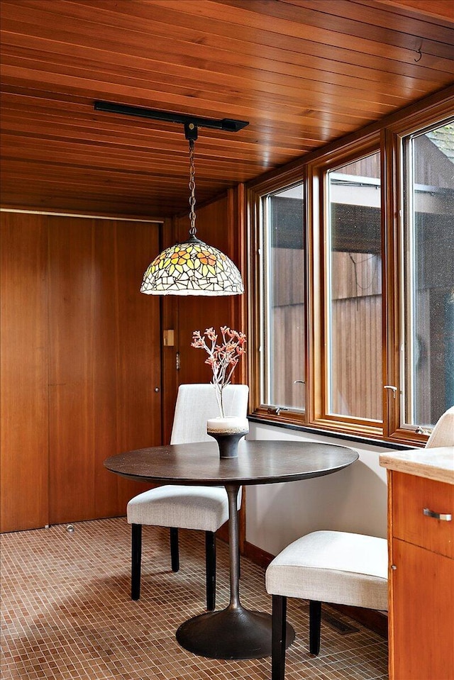 dining area with wood ceiling and wooden walls
