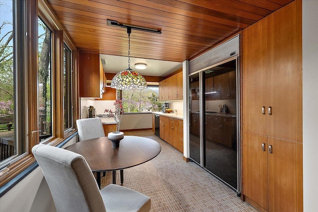 dining space featuring light carpet, wood ceiling, and baseboards
