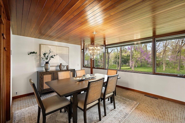 carpeted dining area with baseboards and a chandelier