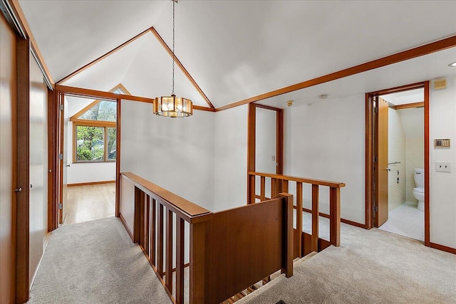 staircase with vaulted ceiling, an inviting chandelier, carpet floors, and baseboards