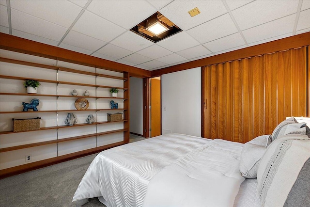 bedroom with a paneled ceiling and carpet floors