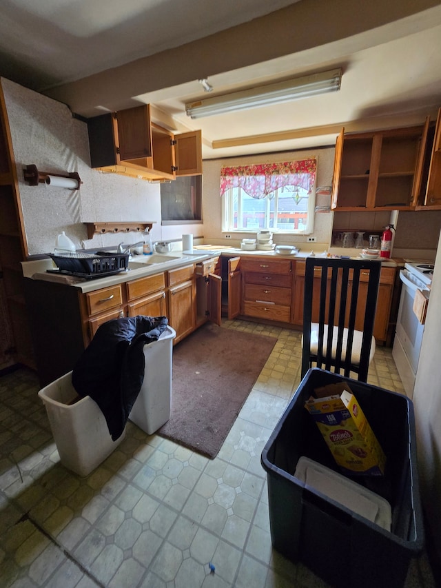 kitchen with white electric range, open shelves, light countertops, and brown cabinets