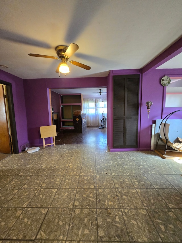 interior space with ceiling fan